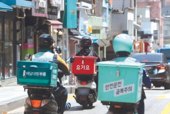 배달 앱 1위 사업자 배달의민족이 매출액에 따라 중개 수수료를 차등 적용하는 방안을 검토하는 것으로 알려졌다. 이에 영세 자영업자와 프랜차이즈 업계의 반응은 엇갈렸다. 사진은 서울의 한 대학가에서 배달 기사가 이동하는 모습. 사진 뉴스1