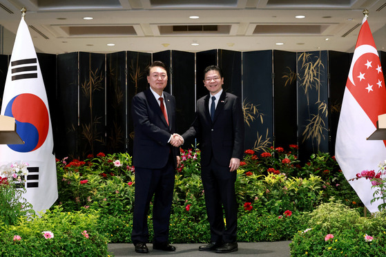 President Yoon Suk Yeol, left, and Singaporean Prime Minister Lawrence Wong shakes hands after their joint press conference following their bilateral summit at Parliament House in Singapore Tuesday. [JOINT PRESS CORPS]