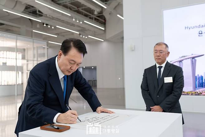 윤석열 대통령이 싱가포르의 주롱 혁신지구에 위치한 '현대차 글로벌 혁신센터'를 방문, 방명록에 서명하고 있다. 사진 우측은 정의선 현대자동차그룹 회장(사진 대통령실)