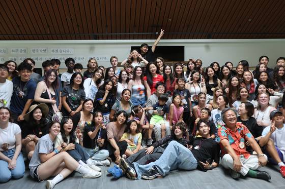 지난 7월 20일 미국 미네소타주 베미지시에 위치한 콘코디아 한국어 마을 ‘숲속의 호수’에선 기숙사 완공을 축하하는 입주식이 열렸다. 사진은 17년간 꾸준히 100억원 가까이 후원금을 지원해준 한국기업 '시몬느'의 박은관 회장(앞줄 오른쪽 오렌지색 셔츠), 축하공연을 연 가수 김창완(중앙) 등 행사에 참가한 이들이 학생들과 함께한 기념 촬영. [사진 임희순]