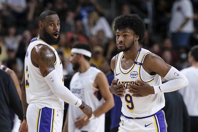 Los Angeles Lakers guard Bronny James (9), right, steps onto the court with Los Angeles Lakers forward LeBron James (23) during the first half of a preseason NBA basketball game Sunday, Oct. 6, 2024, in Palm Desert, Calif. (AP Photo/William Liang)

<저작권자(c) 연합뉴스, 무단 전재-재배포, AI 학습 및 활용 금지>