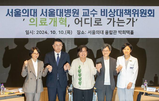 10일 오후 서울대 의대 융합관 박희택홀에서 열린 의료 개혁 토론회 발표자들이 행사 시작 전 손을 맞잡고 있다. 왼쪽부터 정경실 복지부 의료개혁추진단장, 장상윤 대통령실 사회수석, 유미화 녹색소비자연대 대표(진행자), 강희경 서울대 의대 비대위원장, 하은진 서울대 의대 비대위원. /김지호 기자