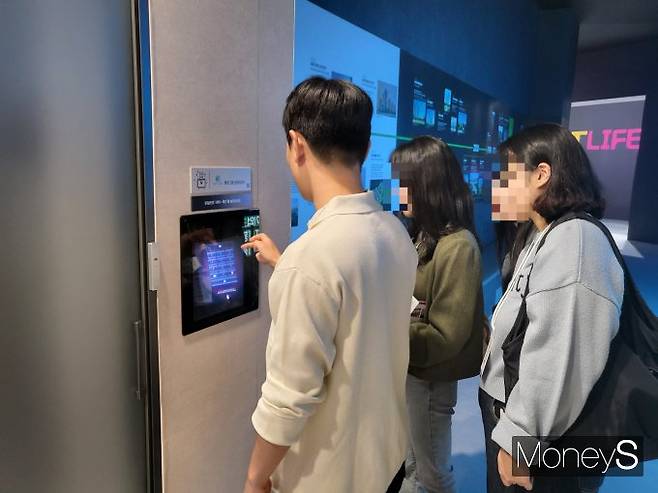 서울시가 한국판 CES를 표방하며 추진한 글로벌 테크 전시회에서 스마트홈에 적용된 미래 기술 체험이 진행됐다. 사진은 '주거의 변화' 쇼룸 입구에서 관람객들이 공동현관 홀로그램 키패드를 조작하는 모습. /사진=이화랑 기자