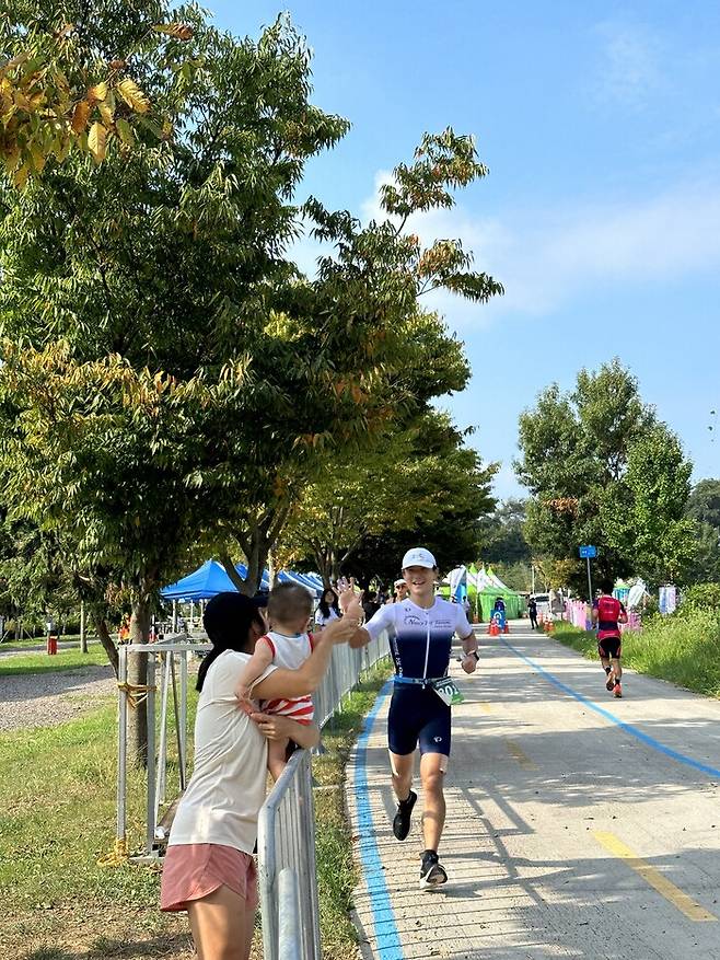 함수연씨(왼쪽)와 또복이가 지난달 1일 전북 익산에서 열린 제24회 문화체육관광부장관배 전국 트라이애슬론 선수권 대회에 출전한 이현수씨를 응원하고 있다. 함수연·이현수 제공