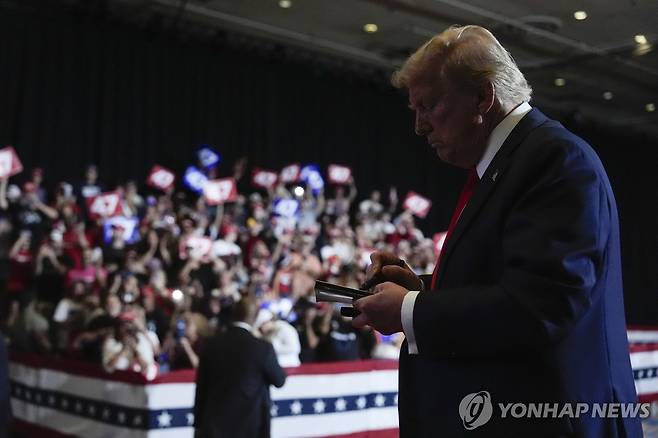 지지자들이 내민 책에 서명해주는 도널드 트럼프 전 대통령 [AP 연합뉴스 자료사진. 재판매 및 DB 금지]