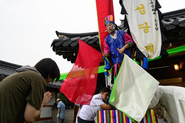 강민정 만신이 지난 8월 26일 서울 중구 서울남산국악당에서 열린 창무국제공연예술제에서 ‘서울 천신굿’을 선보이고 있다. 행운의 상징인 붉은 깃발을 뽑은 신도에게 신의 말을 전하고 있는 모습. 하상윤 기자