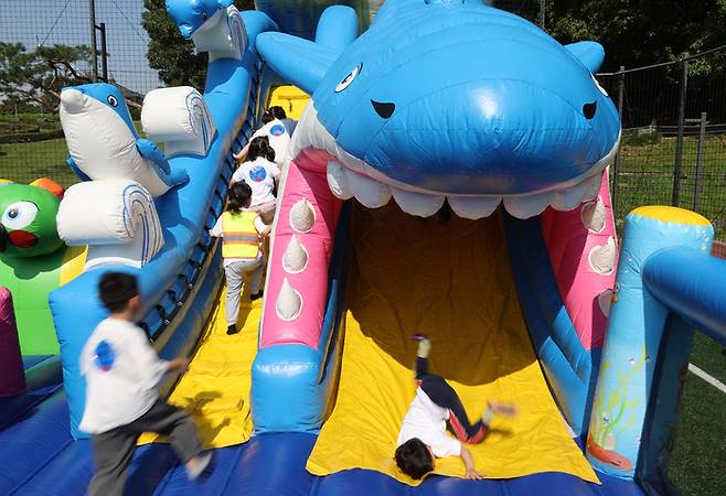 지난 8일 서울어린이공원에서 열린 ‘광진구 어린이집연합회 하나의 날’ 행사에서 어린이들이 상어 미끄럼을 타고 있다. 연합뉴스