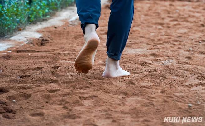 14일 영등포구 안양천 제방 산책로 일원에서 열린 '안양천 황톳길 맨발 걷기' 행사에서 한 시민이 맨발로 황톳길을 걷고 있다.
