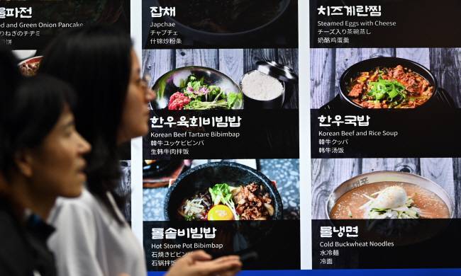 뭘 먹어야하나… 물가 상승으로 가구당 식품비 지출액이 급증한 가운데 13일 서울 도심에서 시민들이 비빔밥 등 한식 메뉴를 판매하는 식당 앞을 지나가고 있다. 한국소비자원에 따르면 서울 기준 비빔밥은 지난 8월 1만962원에서 지난달 1만1038원으로 한 달새 76원이 올랐다. 박윤슬 기자