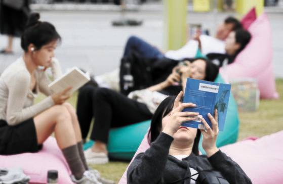 13일 오후 서울 종로구 광화문광장에 마련된 '서울야외도서관 광화문책마당'에서 시민들이 2024년 노벨문학상을 수상한 한강의 소설 『채식주의자』를 읽고 있다 뉴스1