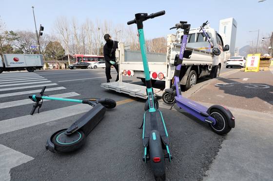 A tow truck picks up abandoned e-scooters near a cross-walk in Seoul Plaza in Jung District, central Seoul, in 2022. [NEWS1]