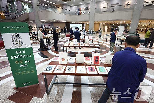 15일 서울 여의도 국회도서관 중앙홀에 마련된 '한강 작가 노벨문학상 수상 특별전'을 찾은 시민들이 책을 살펴보고 있다. 특별전은 이날부터 약 2개월간 열린다. 2024.10.15/뉴스1 ⓒ News1 김민지 기자