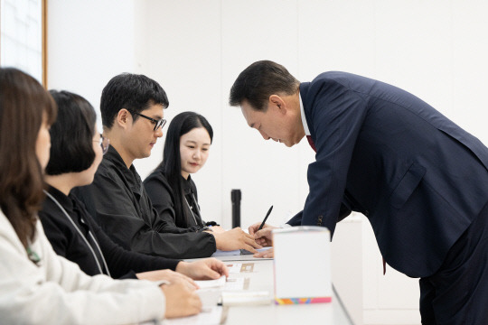 윤석열 대통령이 서울시교육감 보궐선거 투표 날인 16일 서울 용산구 용산공예관 투표소에서 본인 확인 뒤 서명하고 있다.[대통령실 제공]