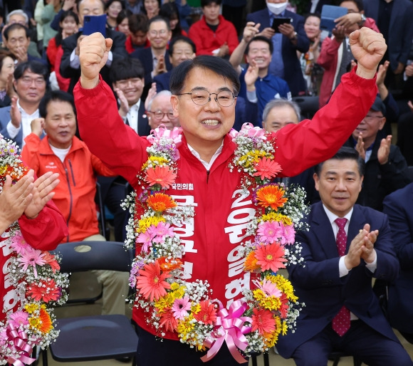 윤일현 국민의힘 금정구청장보궐선거 후보가 16일 오후 부산 금정구 선거사무소에서 당선이 유력해지자 꽃다발을 목에걸고 환호하고 있다. 2024.10.16. 연합뉴스