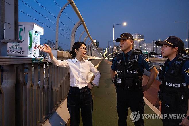 '생명의 전화' 살펴보는 김건희 여사 (서울=연합뉴스) 진성철 기자 = 김건희 여사가 10일 '세계 자살 예방의 날'을 맞아 서울 마포대교에서 마포경찰서 용강지구대 근무자와 함께 '생명의 전화'를 살펴보며 대화하고 있다. 2024.9.10  [대통령실 제공. 재판매 및 DB 금지] zjin@yna.co.kr