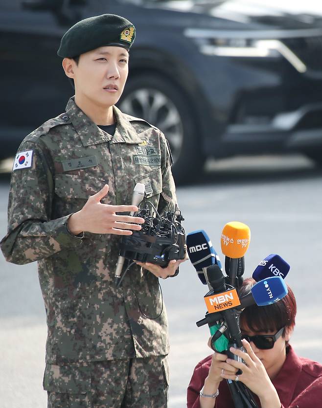 BTS member Jin, right, holds the microphones for bandmate J-Hope on Oct. 17 in Wonju, Gangwon. [NEWS1]