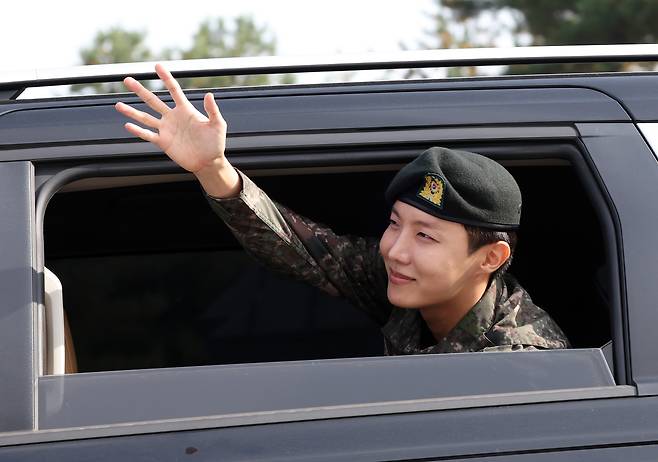 J-Hope of boy band BTS waves to his hands to fans as he leaves his base camp in Wonju, Gangwon, after finishing his mandatory military duty on Oct. 17. [YONHAP]