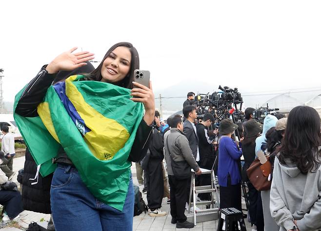 A fan poses for photos while waiting for BTS member J-Hope in front of his base camp in Wonju, Gangwon, on Oct. 17. [YONHAP]