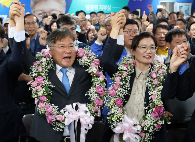 16일 오후 전남 영광군수 재선거에서 당선이 확실시된 더불어민주당 장세일 후보가 배우자 정수미씨와 화환을 목에 걸고 지지자들에게 인사하고 있다. 연합뉴스