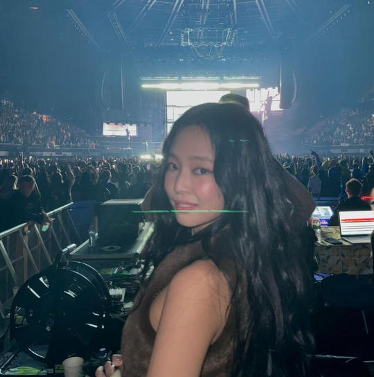 제니는 깊은 브라운 컬러의 퍼 베스트를 입고 무대 뒤에서 여유롭게 포즈를 취하고 있다.사진=제니 SNS