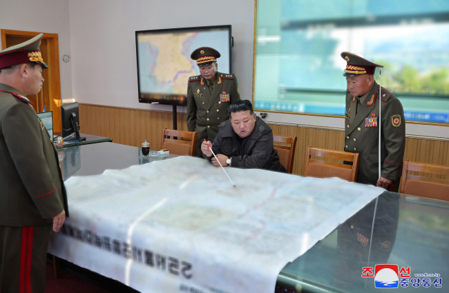 지도까지 펼치고… 김정은(오른쪽 두 번째) 북한 국무위원장이 17일 인민군 제2군단 지휘부를 방문, 책상 위에 대형 서울 작전지도를 펼쳐놓고 무언가를 가리키고 있다. 김 위원장 뒤로는 대형 TV 화면에 남북 경계를 파란 선으로 굵게 표시한 한반도 중부 지방 지도가 띄워져 있다. 조선중앙통신 연합뉴스