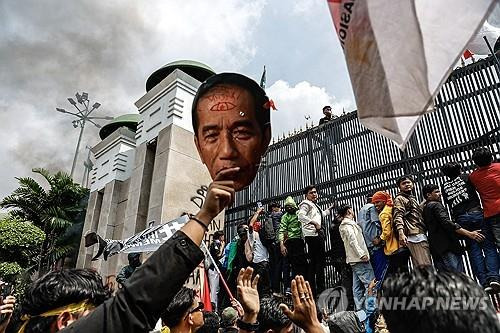 인도네시아 선거법 개정 반대 시위 지난 8월 22일 인도네시아 국회 앞에서 선거법 개정에 반대하는 시위대가 조코위 대통령의 사진을 들고 국회 진입을 시도하고 있다. 
[EPA 연합뉴스 자료사진 제공. 재판매 및 DB 금지]