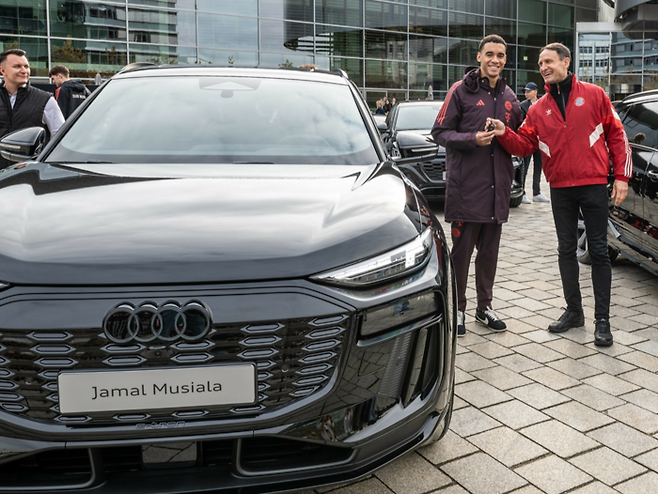 자말 무시알라가 아우디 관계자로부터 아우디 Q6 e-트론의 차키를 받고 있다.