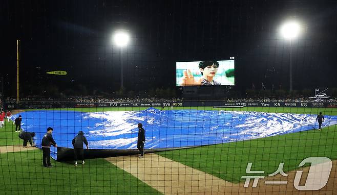 21일 오후 광주 기아챔피언스필드에서 열린 프로야구 '2024 신한 SOL 뱅크 KBO 포스트시즌' 한국시리즈 1차전 삼성 라이온즈와 KIA 타이거즈의 경기를 앞두고 비가 내리자 관계자들이 방수포를 깔고 있다. 2024.10.21/뉴스1 ⓒ News1 오대일 기자