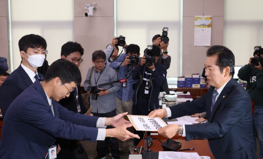 정청래 법사위원장(오른쪽)이 21일 서울 여의도 국회에서 열린 법제사법위원회의 대검찰청 대상 국정감사에서 김건희 여사 동행명령장을 발부, 경위들에게 전달하고 있다. 연합뉴스