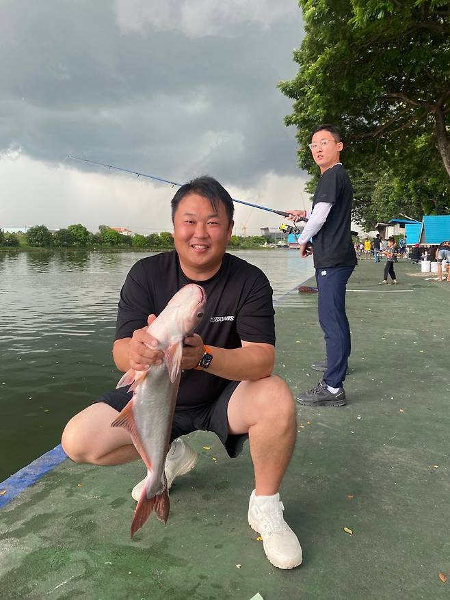 오진혁이 태국 전지훈련 중 휴식일에 낚시로 잡은 자이언트 메기를 들어보이고 있다. 오진혁 제공