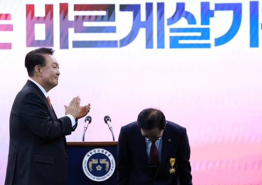 지난 10월17일 윤석열 대통령이 강원특별자치도 강릉시 아이스 아레나에서 열린 2024년 바르게살기운동 전국회원대회에서 김상동(오른쪽) 바르게살기운동 충청북도협의회 수석부회장에게 국민훈장 목련장을 수여한 뒤 박수치고 있다.<연합뉴스 사진>