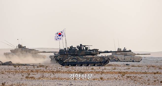 한국 육군의 K2전차(중앙)가 카타르 지상군의 레오파르트2A7 전차(왼쪽, 오른쪽)와 함께  카타르 알 칼라엘 훈련장에서 기동하고 있다.  육군 제공