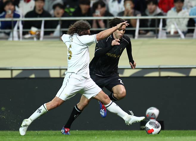 Carles Puyol (left) and Kaká compete for the ball during the Nexon Icons Match at Seoul World Cup Stadium in western Seoul on Sunday. (Yonhap)