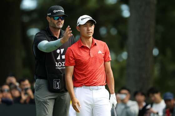 Collin Morikawa talks with his caddie before his tee shot on the 5th hole during the final round of Zozo Championship at Accordia Golf Narashino Country Club on Oct. 22, 2023 in Chiba, Japan. [GETTY IMAGES]