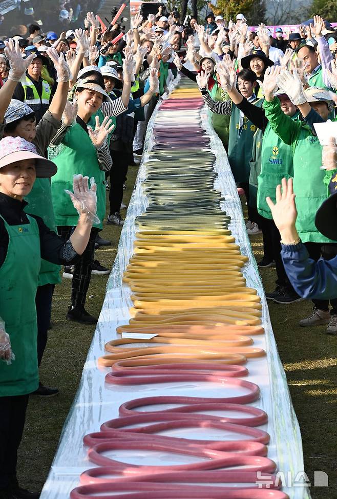 [이천=뉴시스] 김종택기자 = '제23회 이천 쌀 문화축제'가 열린 16일 경기도 이천시 모가면 이천농업테마공원에서 600m 오색 가래떡 만들기가 진행되고 있다. 2024.10.16. jtk@newsis.com