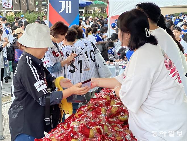 잠실야구장을 방문한 관중이 ‘우리과일 나눔 행사’ 이벤트에서 사과를 받고 있다. 한국과수농협연합회 제공