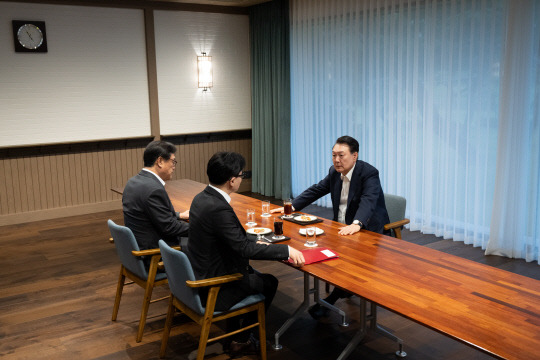 윤석열 대통령이 21일 서울 용산 대통령실 앞 파인그라스에서 국민의힘 한동훈 대표를 만나 대화하고 있다. 이 자리에는 정진석 대통령 비서실장이 배석했다. [대통령실 제공]