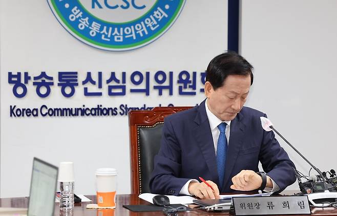 류희림 방송통신심의위원장이 지난 8월28일 오전 서울 양천구 목동 방송통신심의위원회에서 열린 텔레그램에 기반한 불법합성물(딥페이크)인 성범죄 영상물 제작 및 유포 사건 관련 전체회의에 앞서 시계를 보고 있다. 김봉규 선임기자 bong9@hani.co.kr