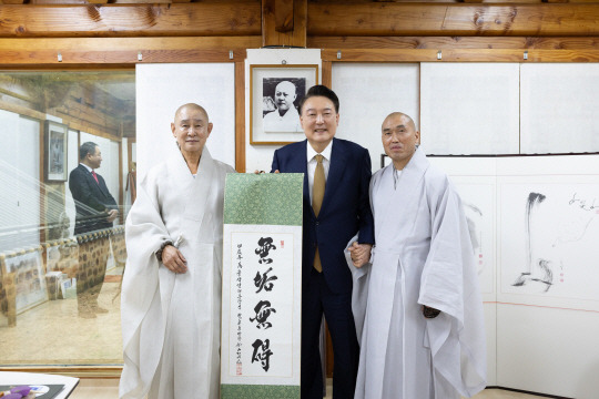 윤석열 대통령이 22일 부산 금정구 범어사를 찾아 차담 뒤 주지 정오스님(오른쪽)이 쓴  무구무애(無垢無碍) 족자를 선물 받은 뒤 기념촬영을 하고 있다. 왼쪽부터 방장 정여스님, 윤 대통령, 주지 정오스님. 대통령실 제공