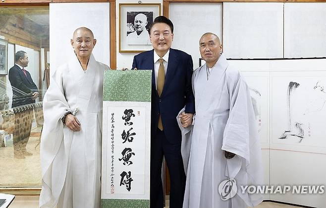 정오스님이 쓴 족자 선물 받은 윤석열 대통령 (부산=연합뉴스) 홍해인 기자 = 윤석열 대통령이 22일 부산 금정구 범어사를 찾아 차담 뒤 주지 정오스님(오른쪽)이 쓴  무구무애(無垢無碍) 족자를 선물 받은 뒤 기념촬영을 하고 있다. 
    왼쪽부터 방장 정여스님, 윤 대통령, 주지 정오스님. 2024.10.22 [대통령실 제공. 재판매 및 DB 금지] hihong@yna.co.kr