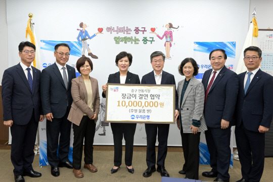 김길성(오른쪽 네번째) 중구청장, 김정안(오른쪽 두번째) 중구 전통시장 상권발전소 대표, 정현옥(왼쪽 네번째) 우리은행 금융소비자보호그룹장이 관계자들과 기념촬영을 하고 있다. [우리은행 제공]