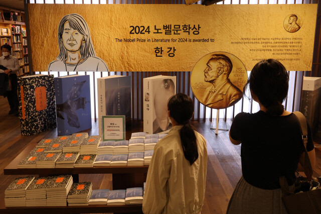 지난 14일 서울 종로구 교보문고 광화문점에 마련된 한강 작가 노벨문학상 수상 기념 설치물을 시민들이 바라보고 있다. 김혜윤 기자 unique@hani.co.kr