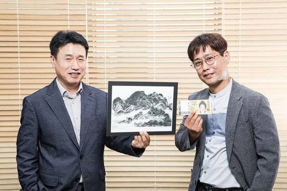 지난 17일 오후 서울 마포구 창전동 한국조폐공사 오롯디윰관에서 오만원권 신사임당 초상을 담당한 가성현 디자인 총괄 책임(오른쪽)과 '인왕제색도 요판화'를 작업한 신인철 수석선임이 각자 작품을 들고 포즈를 취했다. 김경록 기자