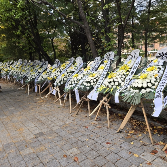 23일 성남시 분당의 A초등학교 앞 등굣길에 학교폭력  근절과 가해학생 부모인 시의원의 사퇴를 요구하는 근조 화환 수십개가 줄지어 있다.  신동원 기자