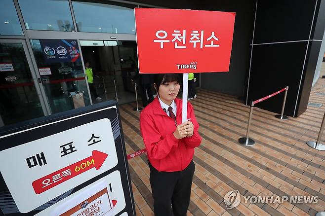 한국시리즈 개막전, 오늘도 '우천 취소' (광주=연합뉴스) 정회성 기자 = 22일 광주 기아챔피언스필드에서 재개될 예정이었던 2024 신한 SOL 뱅크 KBO 한국시리즈 KIA 타이거즈-삼성 라이온즈의 1차전과 2차전이 그라운드 사정과 비 예보로 인해 모두 취소돼 경기장 보안요원이 안내판을 손에 들고 있다. 2024.10.22 hs@yna.co.kr