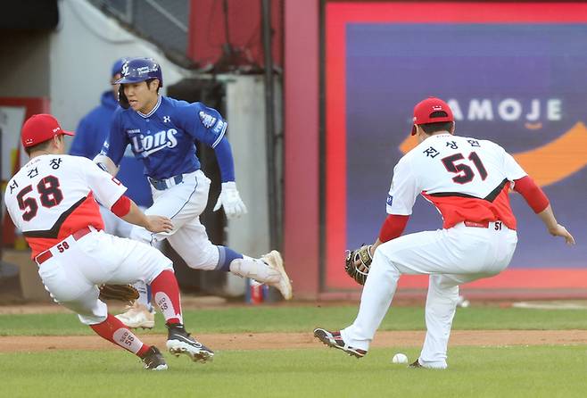 삼성 김지찬(가운데)이 23일 광주-기아 챔피언스 필드에서 열린 2024 KBO 한국시리즈 1차전 KIA와 경기 7회초 무사 1루에서 번트를 댄 후 1루로 뛰고 있다. 사진 | 광주=연합뉴스