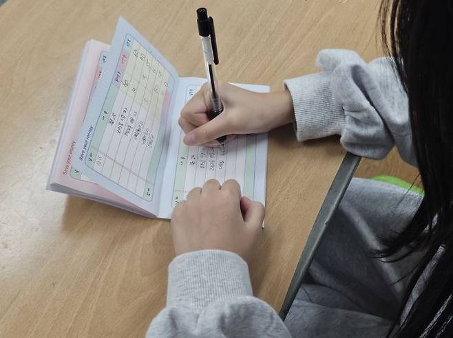 경기 화성 효행초등학교 6학년 4반의 한 학생이 급여 통장을 정리하고 있다. [사진=전영주 기자 @ange]