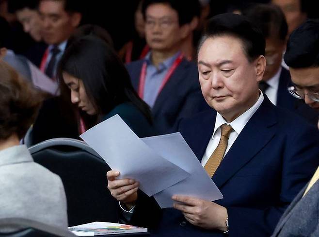 윤석열 대통령이 22일 부산항국제전시컨벤션센터(BPEX)에서 열린 '27회 IAVE 2024 부산세계자원봉사대회' 개회식에서 자료를 살피고 있다. ⓒ연합뉴스