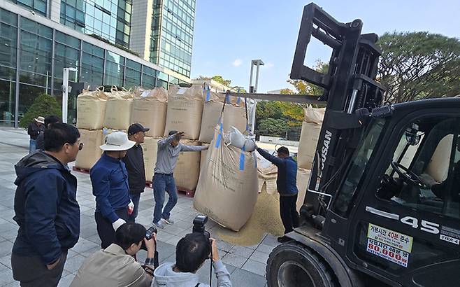 전국농민회총연맹(이하 ‘전농’)과 전국쌀생산자협회가 24일 오후 서울 농협중앙회 본관 앞에서 기자회견을 열고 나락값 7만원 공약 이행 등 즉각적인 쌀값 안정화 대책마련을 촉구하는 가운데 나락포대에 항의 피켓이 놓여있다.