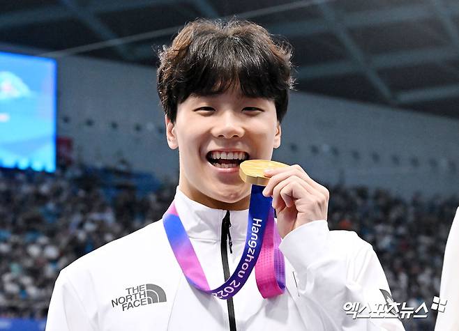 중국 항저우 올림픽 스포츠센터 수영장에서 열린 '2022 항저우 아시안게임' 남자 자유형 50ｍ 경기에서 대한민국 지유찬이 21초72로 아시안게임 신기록을 세우며 금메달을 차지했다. 시상식에서 금메달을 수상하고 있는 지유찬. 엑스포츠뉴스DB